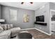 Cozy living room with neutral walls, wood floors, a comfortable sectional sofa, and bright windows at 4043 E Carla Vista Dr, Gilbert, AZ 85295