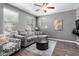 Cozy living room with neutral walls, wood floors, a comfortable sectional sofa, and bright windows at 4043 E Carla Vista Dr, Gilbert, AZ 85295
