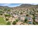 Scenic aerial view of a residential community with mountain backdrop and homes with swimming pools and solar panels at 4239 W Reddie Loop, Phoenix, AZ 85083