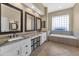 Bathroom features a large vanity with double sinks, storage, and bathtub at 4239 W Reddie Loop, Phoenix, AZ 85083