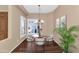 Dining area with wood floors, modern chandelier, and elegant seating arrangement at 4239 W Reddie Loop, Phoenix, AZ 85083