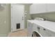 Functional laundry room with washer, dryer, sink and upper cabinets at 4239 W Reddie Loop, Phoenix, AZ 85083