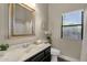 Traditional bathroom features a vanity with a decorative framed mirror and adjacent window at 4338 E Hamblin Dr, Phoenix, AZ 85050