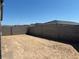 Backyard featuring dirt and block wall fence under a clear, blue sky at 5573 S 246Th Ave, Buckeye, AZ 85326