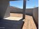 Backyard featuring concrete slab, dirt area, and block wall fence under a clear, blue sky at 5573 S 246Th Ave, Buckeye, AZ 85326