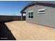 Backyard featuring dirt, stucco wall, and part of the home in the background under blue sky at 5573 S 246Th Ave, Buckeye, AZ 85326