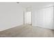 Bright bedroom featuring neutral carpet, closet, and a door to another room at 5573 S 246Th Ave, Buckeye, AZ 85326