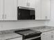 Close up of a modern kitchen with white cabinets and stainless steel appliances at 5573 S 246Th Ave, Buckeye, AZ 85326