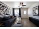 Modern living room with gray sofa, tiled floors, and stylish window treatments at 6012 W Flower St, Phoenix, AZ 85033