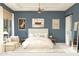 Serene bedroom features blue walls, a comfortable bed, and an ensuite sliding barn door bathroom at 667 E Brown Way, San Tan Valley, AZ 85140