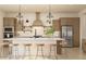 Stylish kitchen features modern cabinetry, stainless steel appliances, a large island with seating, and elegant pendant lighting at 667 E Brown Way, San Tan Valley, AZ 85140