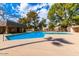 Sparkling community swimming pool with lounge areas, mature trees and blue skies at 7126 N 19Th Ave # 224, Phoenix, AZ 85021