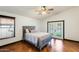 Bedroom with hardwood floors, a ceiling fan, a bed, a window, and a glass door leading to a garden at 7253 S Terrace Rd, Tempe, AZ 85283