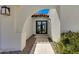 Close up on the entryway of a modern home with an arched walkway and black framed glass door at 7328 E Laredo Ln, Scottsdale, AZ 85250