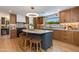Modern kitchen featuring wood cabinets, geometric backsplash, black appliances, and an island with seating at 7328 E Laredo Ln, Scottsdale, AZ 85250