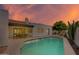 Backyard swimming pool with attached patio and outdoor seating surrounded by lush desert landscaping at sunset at 7328 E Laredo Ln, Scottsdale, AZ 85250