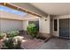 Charming front courtyard with lush greenery, decorative planters, and covered entry leading to the front door at 7649 W Dahlia Dr, Peoria, AZ 85381