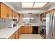 Bright kitchen with stainless steel appliances, wood cabinets, and a window overlooking the backyard at 7649 W Dahlia Dr, Peoria, AZ 85381