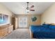 Inviting main bedroom with a plush carpet, ceiling fan, and private access to the backyard pool at 7649 W Dahlia Dr, Peoria, AZ 85381
