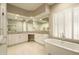 Bright main bathroom with double sinks, custom mirrors, and a soaking tub under a window at 8036 E Mercer Ln, Scottsdale, AZ 85260
