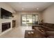 Bright living room with a fireplace, tile floors, and large sliding glass doors to the patio at 8036 E Mercer Ln, Scottsdale, AZ 85260