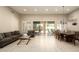 Bright living room and dining area with sliding glass doors to backyard and neutral tile flooring throughout at 8036 E Mercer Ln, Scottsdale, AZ 85260