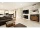 Spacious living room featuring a modern fireplace, a flat-screen TV, and an open floor plan to the kitchen at 8036 E Mercer Ln, Scottsdale, AZ 85260