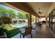 A relaxing covered patio offering views of the pool, waterfall, and lush landscaping at 8036 E Mercer Ln, Scottsdale, AZ 85260