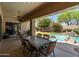 This patio has a table and chairs with a nice view of the waterfall and pool at 8036 E Mercer Ln, Scottsdale, AZ 85260