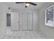 Sunlit bedroom includes ceiling fan, closet space, a bright window, and sleek tile flooring at 8132 W Pierson St, Phoenix, AZ 85033