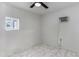 Bright bedroom featuring a window and ceiling fan with tile flooring at 8132 W Pierson St, Phoenix, AZ 85033