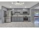 Modern kitchen featuring gray cabinets, stainless steel appliances, and tiled floors at 8132 W Pierson St, Phoenix, AZ 85033
