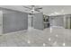 Bright living space with gray walls, tile flooring, ceiling fan and open access to a kitchen at 8132 W Pierson St, Phoenix, AZ 85033