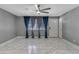 Inviting living room with large windows, gray walls, tiled floors, and stylish curtains at 8132 W Pierson St, Phoenix, AZ 85033