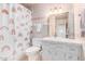 Charming bathroom with rainbow shower curtain, tile walls, toilet, vanity, and a mirror at 8310 E Glenrosa Ave, Scottsdale, AZ 85251