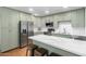 Bright kitchen with stainless steel appliances, island with barstools, and stylish light green cabinetry at 8310 E Glenrosa Ave, Scottsdale, AZ 85251