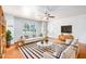 Bright living room with hardwood floors, neutral furniture, and large window with plantation shutters at 8310 E Glenrosa Ave, Scottsdale, AZ 85251