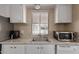 Bright kitchen sink area with white cabinets and a window that offers natural light at 8730 E Dewan Ave, Mesa, AZ 85208