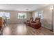 Cozy living room with wood-look flooring and large windows, creating a bright and inviting space at 8730 E Dewan Ave, Mesa, AZ 85208
