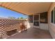 This covered patio is complete with a wooden rocking chair and storage bench at 8730 E Dewan Ave, Mesa, AZ 85208