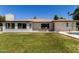 A home's backyard featuring a dining set, patio, pool, and well-maintained lawn at 9436 N 41St Dr, Phoenix, AZ 85051
