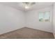 A carpeted bedroom featuring a bright window and ceiling fan at 9436 N 41St Dr, Phoenix, AZ 85051