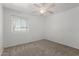 A carpeted bedroom with a ceiling fan and window that provides natural light at 9436 N 41St Dr, Phoenix, AZ 85051