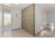 Bright entryway with tile flooring, a brick accent wall, and a view of the front door at 9436 N 41St Dr, Phoenix, AZ 85051