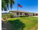 Exterior view of a home with a lush green lawn and an American flag waving proudly at 9436 N 41St Dr, Phoenix, AZ 85051