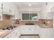 Well-maintained kitchen with white cabinetry, tile countertops, and a garden view at 9436 N 41St Dr, Phoenix, AZ 85051