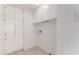 A white laundry room with white storage cabinets and tiled flooring at 9436 N 41St Dr, Phoenix, AZ 85051