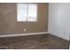 Well-lit bedroom showcasing wood-look flooring, fresh white trim, and a large window at 9501 E Broadway Rd # 254, Mesa, AZ 85208