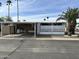 Charming mobile home featuring a covered carport, decorative white lattice, and mature palm trees in a desert landscape at 9501 E Broadway Rd # 254, Mesa, AZ 85208