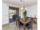 Elegant dining room featuring a stylish chandelier, a dining table, and sliding door access to the patio at 955 E Knox Rd # 137, Chandler, AZ 85225